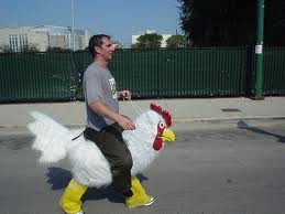 Photo d'un homme chevauchant un costume de poulet géant