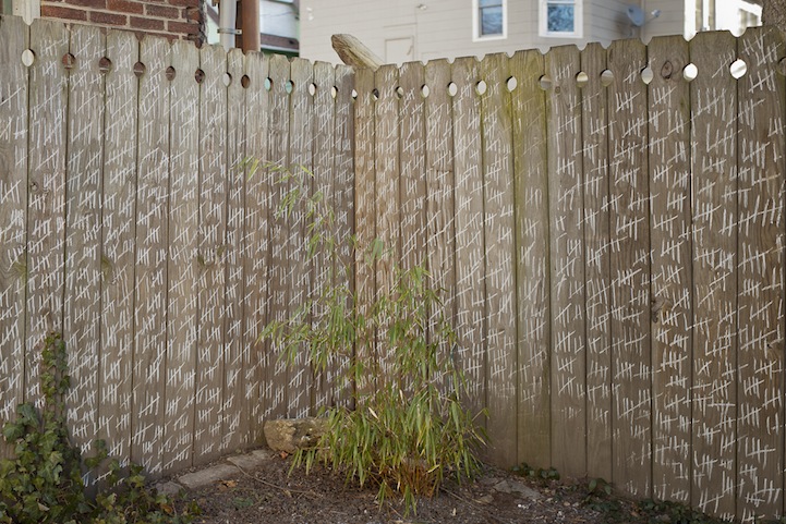 Photo d'un mur avec des barres écrites à la craie pour compter les jours